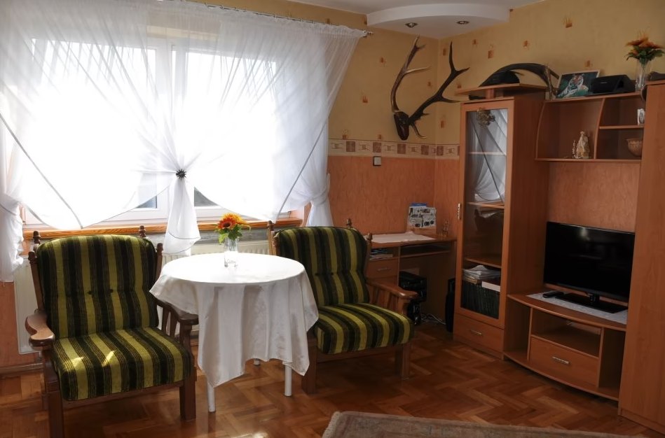 Pokój z fotelami, stolikiem i telewizorem